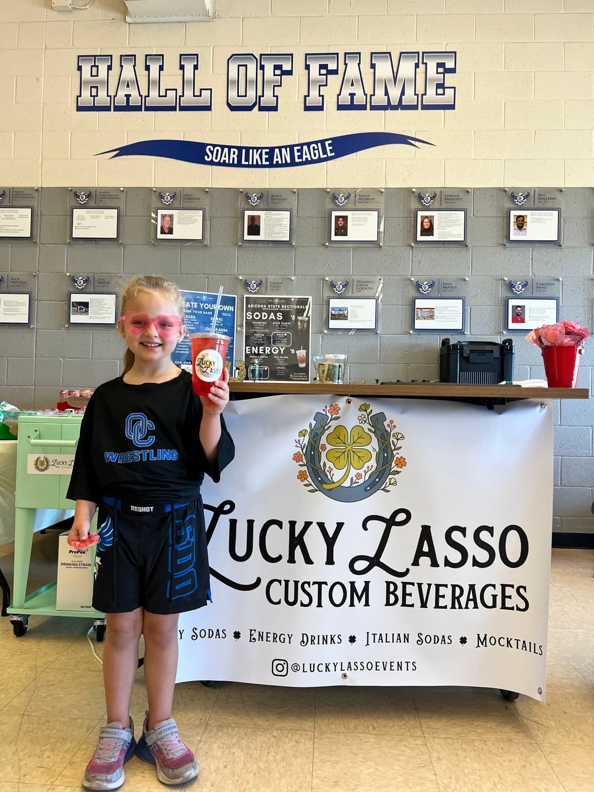 Young fan with a Lucky Lasso drink at a wrestling event